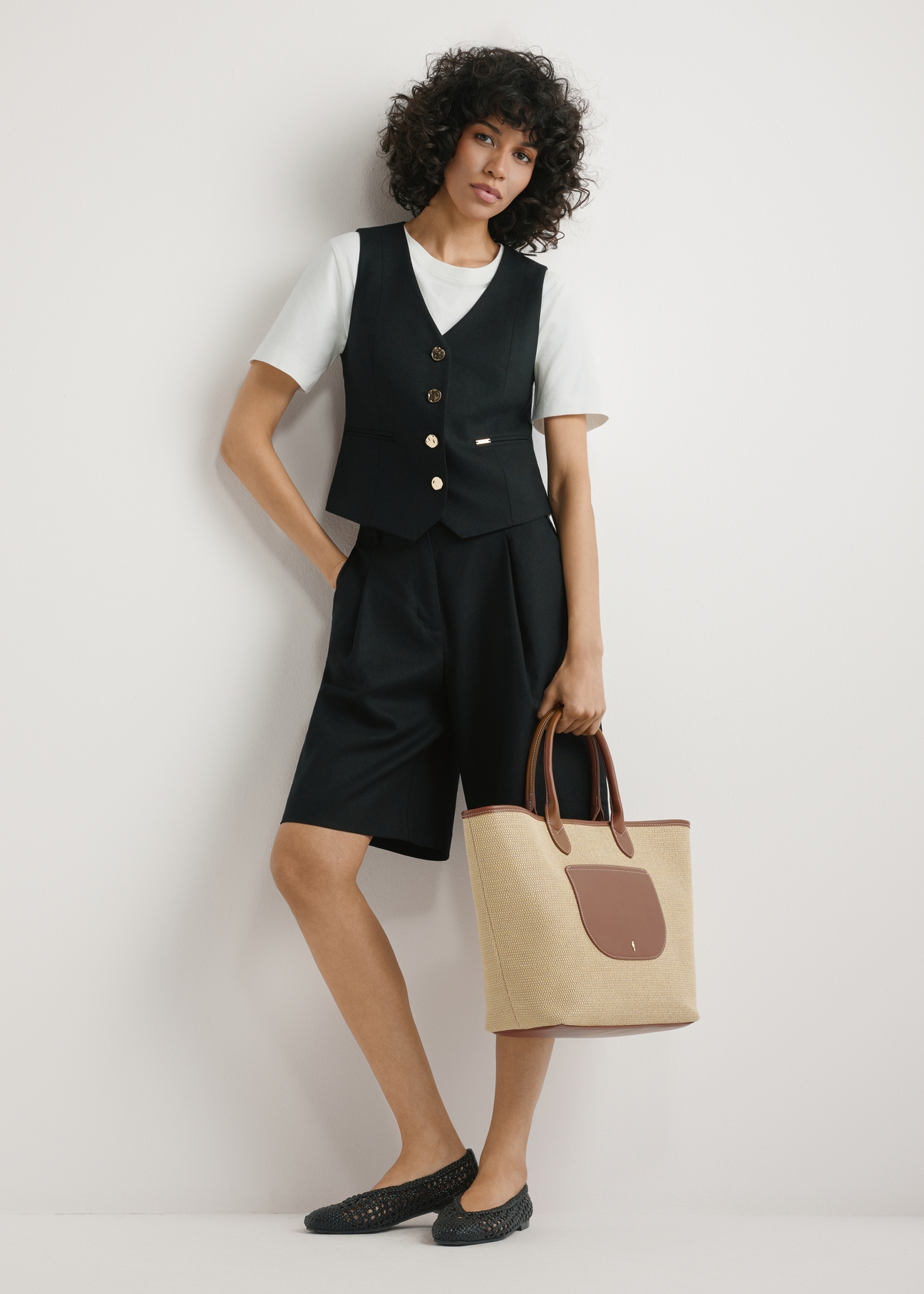 Велика жіноча солом'яна сумка TOREC-1229-1E(W26), вигляд виробу, який тримає модель у руці, на світлому фоні. Видно весь силует.