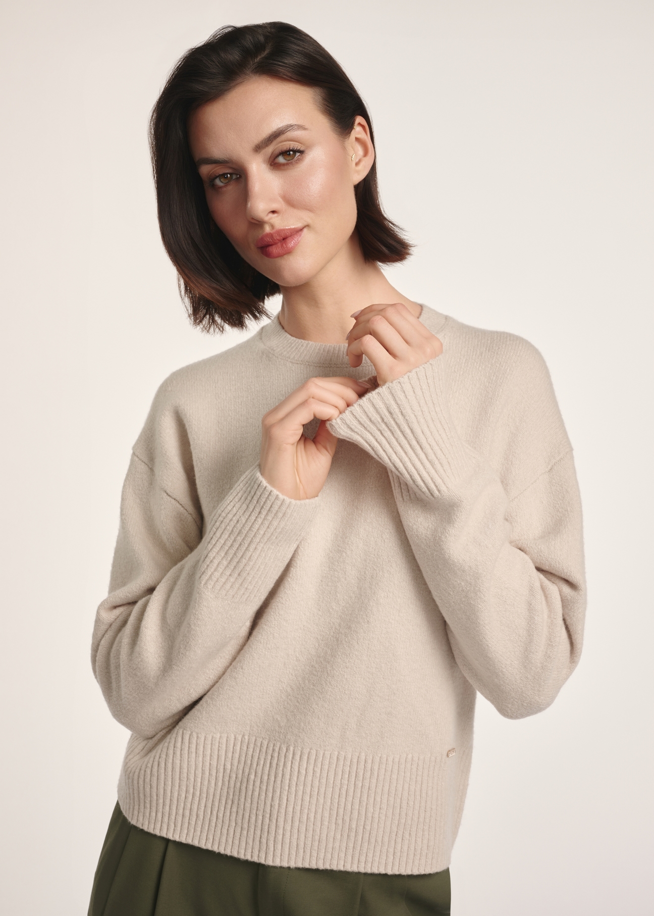 Бежевий жіночий светр SWEDT-0242-80(Z25), вигляд виробу спереду на моделі. Видно половину силуету.