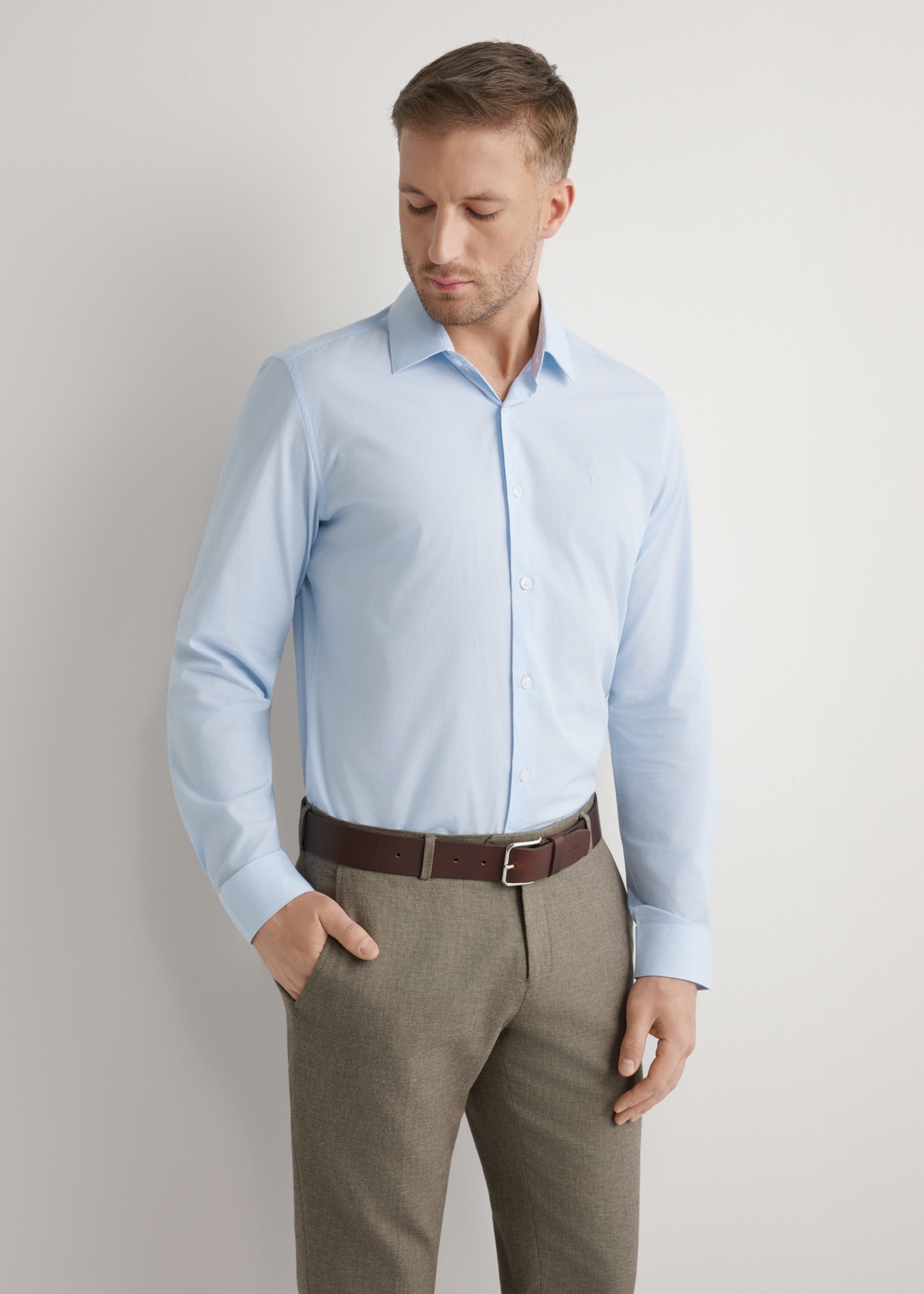 Світло-блакитна чоловіча смугаста сорочка KOSMT-0357-7A(W26), вигляд виробу спереду на моделі. Видно половину силуету.