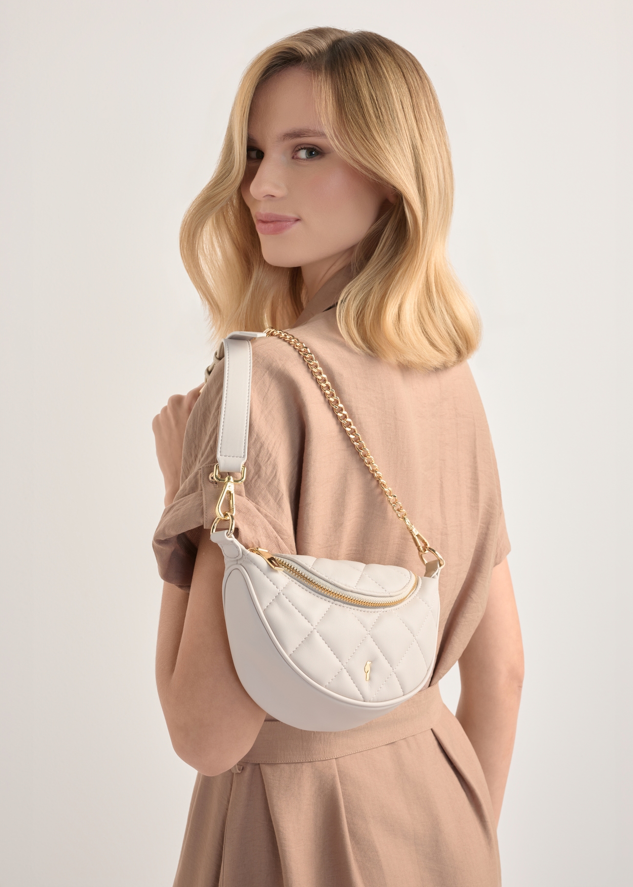 Кремова стьобана жіноча сумка TOREC-1091-0B(W26), вигляд виробу на плечі моделі. Видно половину силуету.