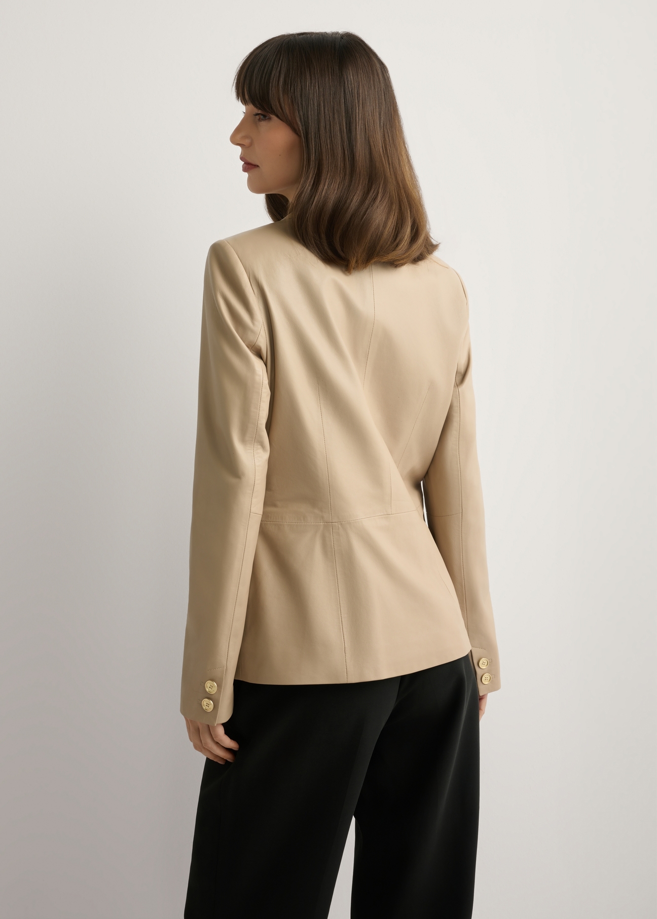 Бежева жіноча шкіряна куртка KURDS-0445-1B(W26), вигляд виробу ззаду на моделі. Видно половину силуету.