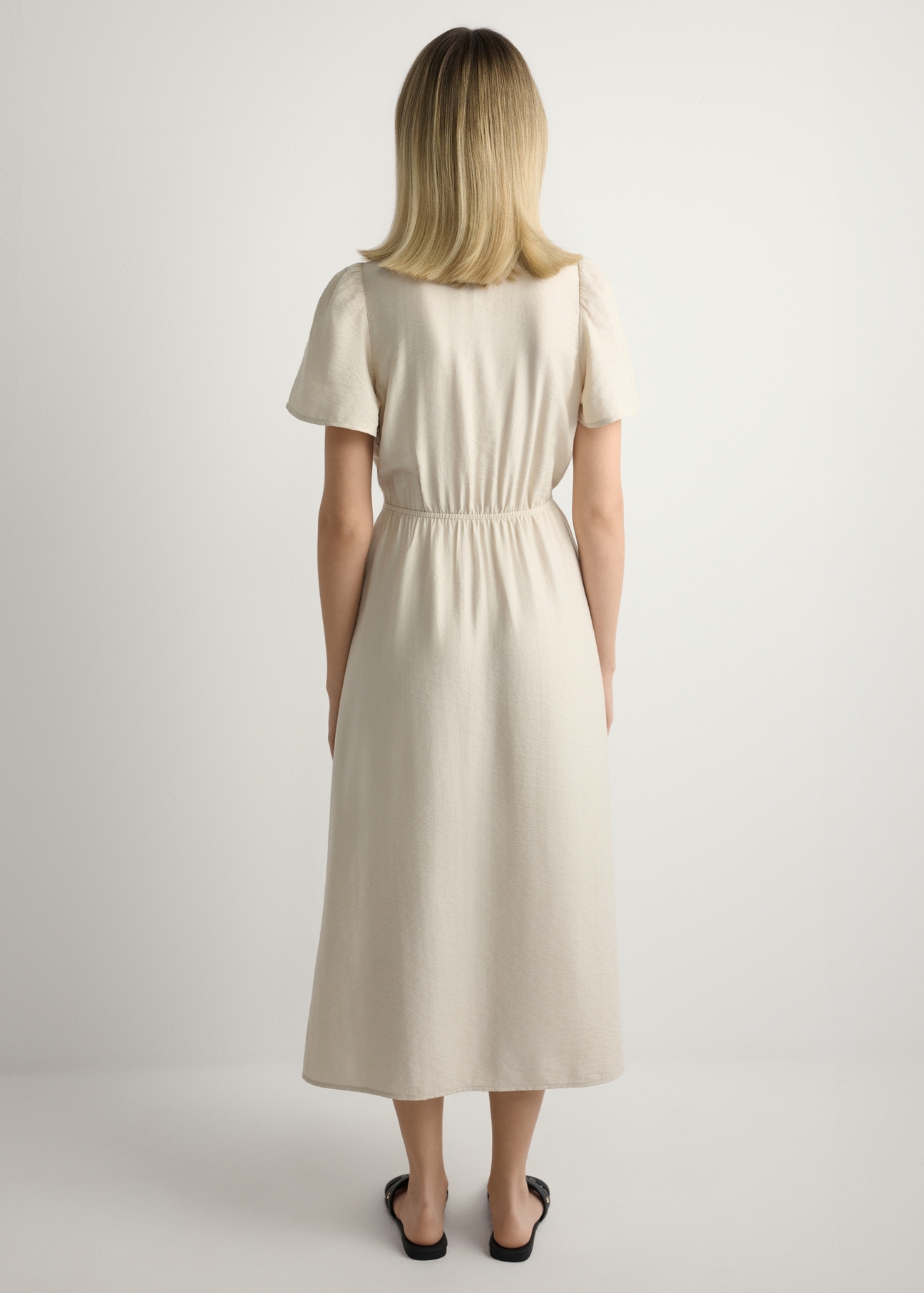 Жіноча світло-бежева сукня SUKDT-0255-1A(W26), вигляд виробу ззаду на моделі. Видно все тіло.