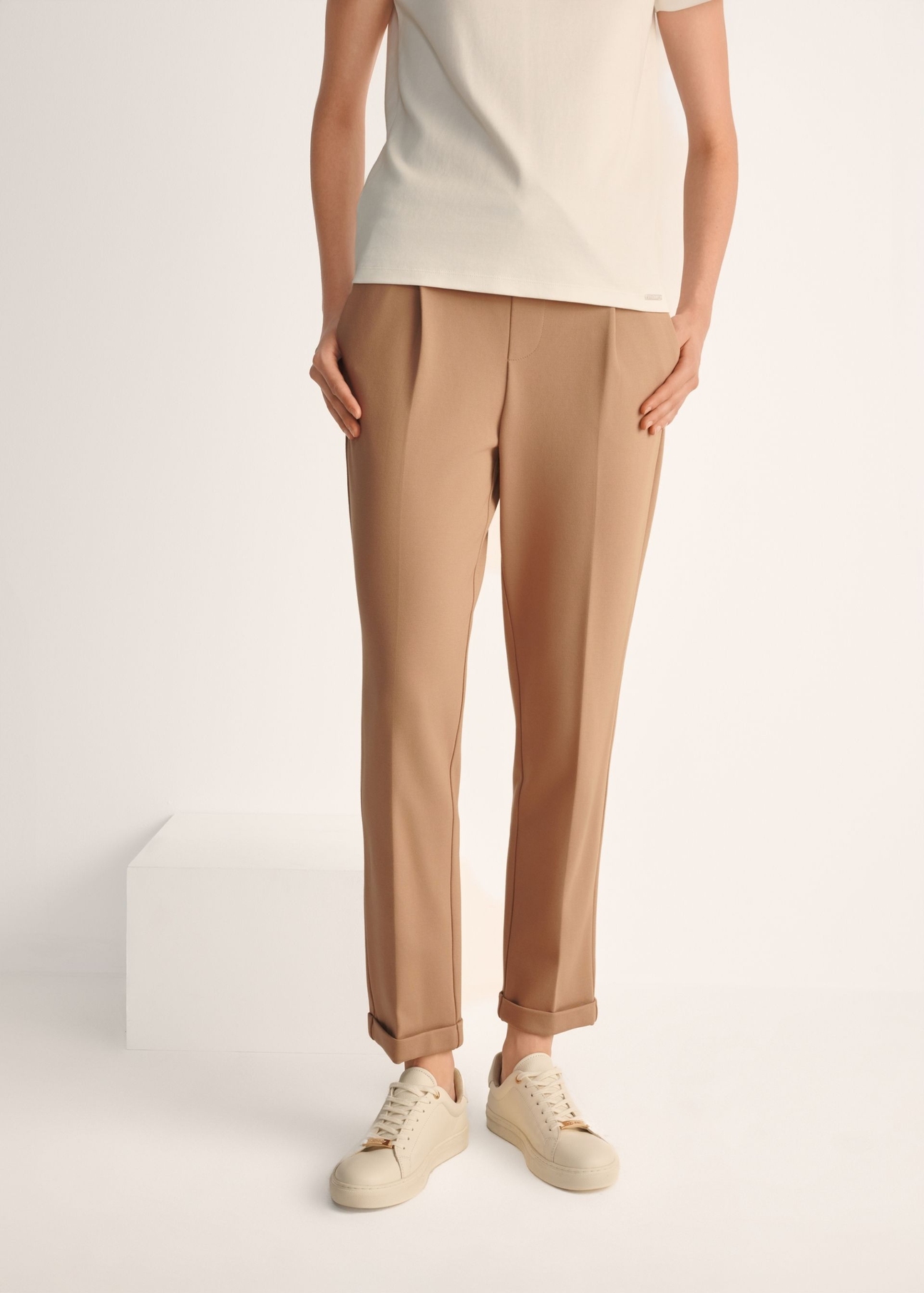 Жіночі білі шкіряні кросівки BUTYD-1068-0B(W26), вигляд виробу на ногах моделі на світлому фоні.