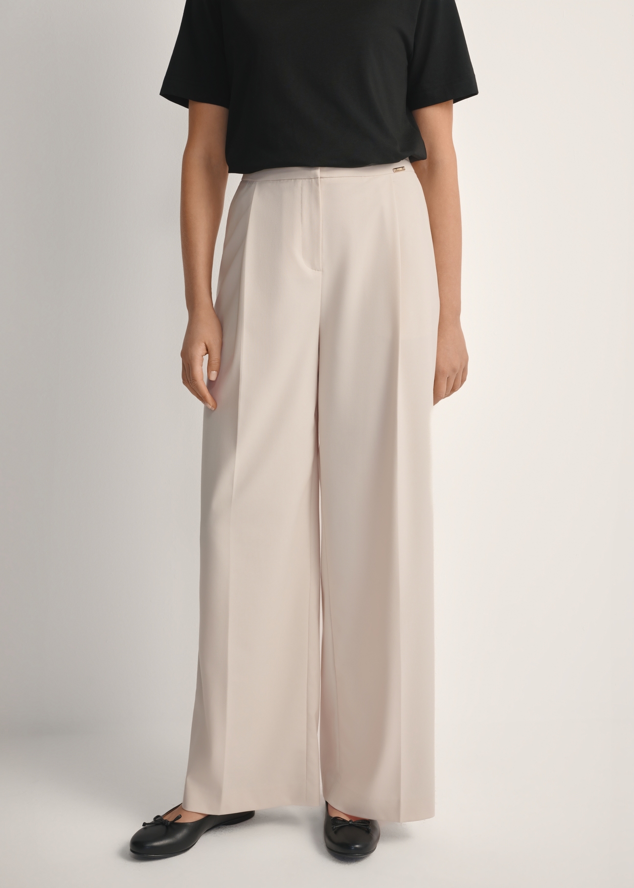 Світло-бежеві жіночі штани SPODT-0119-1A(W26), вигляд виробу спереду на моделі. Видно половину силуету.