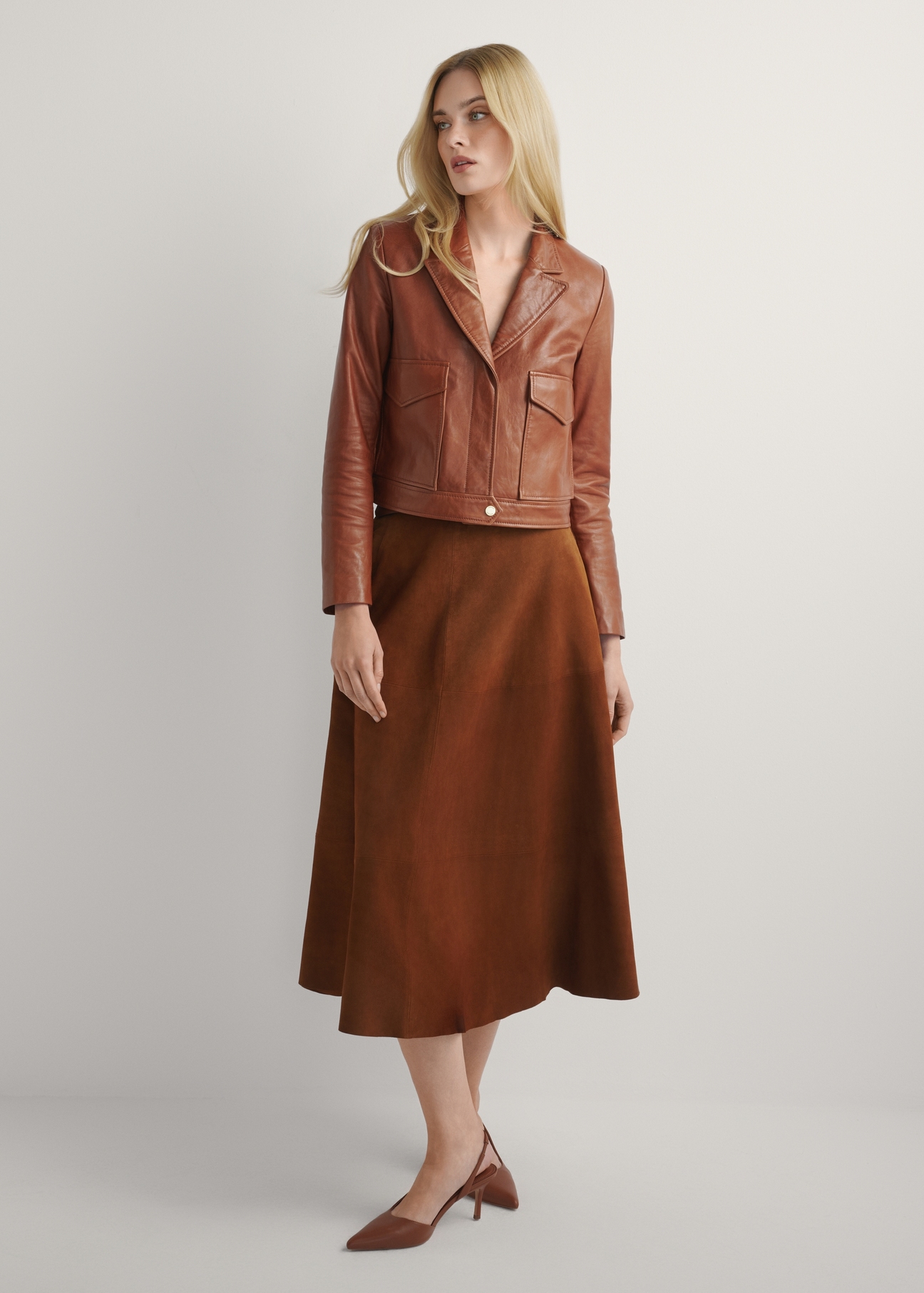 Жіноча коротка шкіряна куртка кольору верблюжого візерунка KURDS-0471-1D(W26), вигляд виробу спереду на моделі. Видно все тіло.