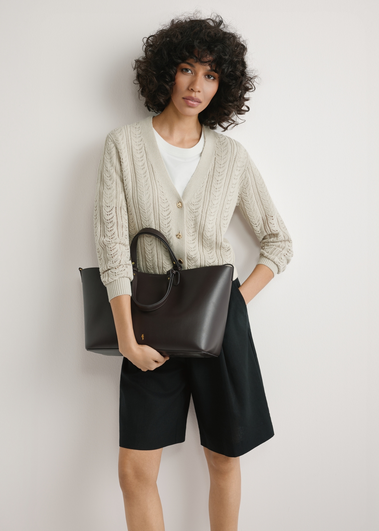 Коричнева жіноча сумка-шопер TOREC-1240-1H(W26), вигляд виробу в руках моделі. Видно половину силуету.