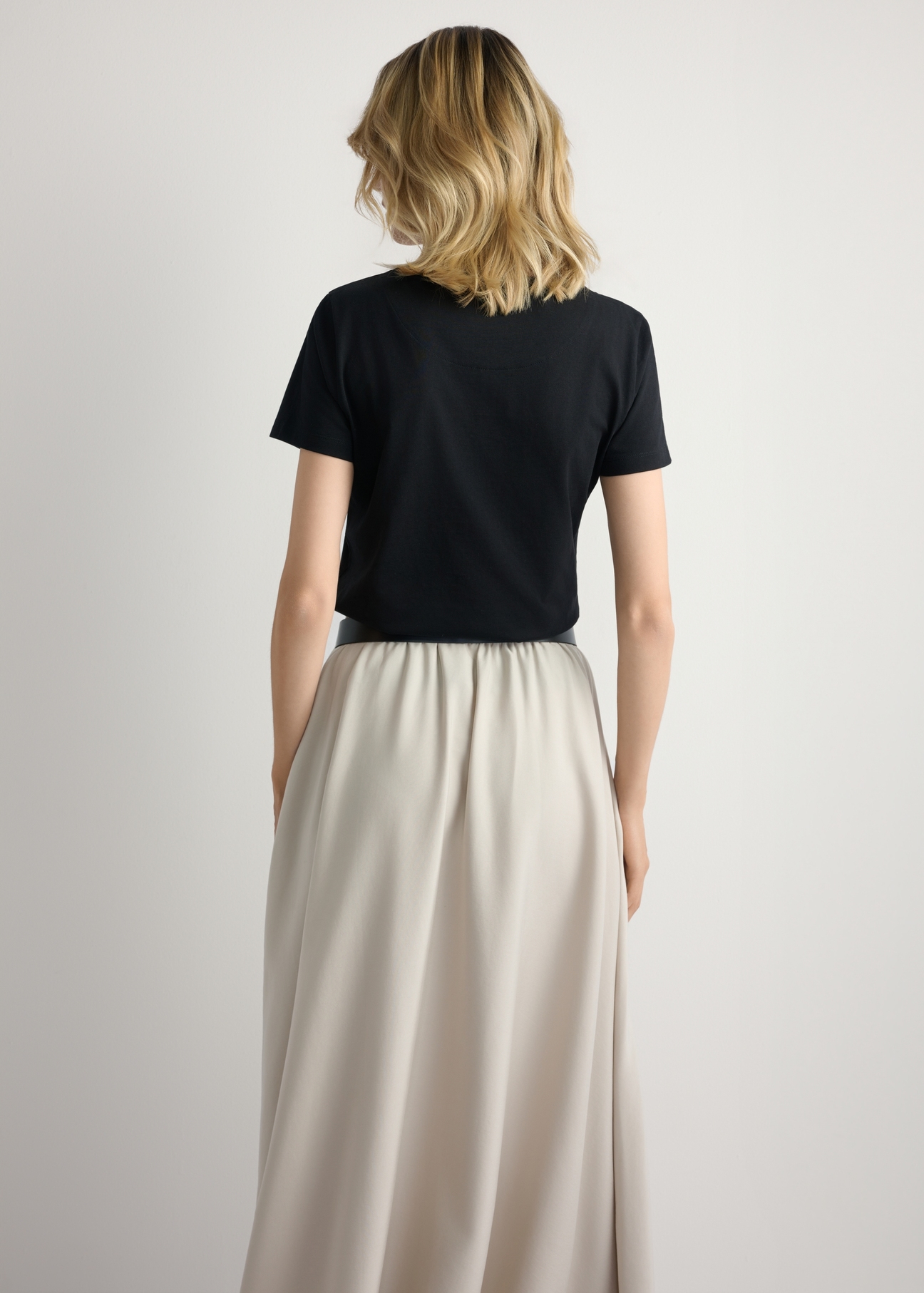 Чорна жіноча футболка з логотипом TSHDT-0157-99(W26), вигляд виробу ззаду на моделі. Видно половину силуету.