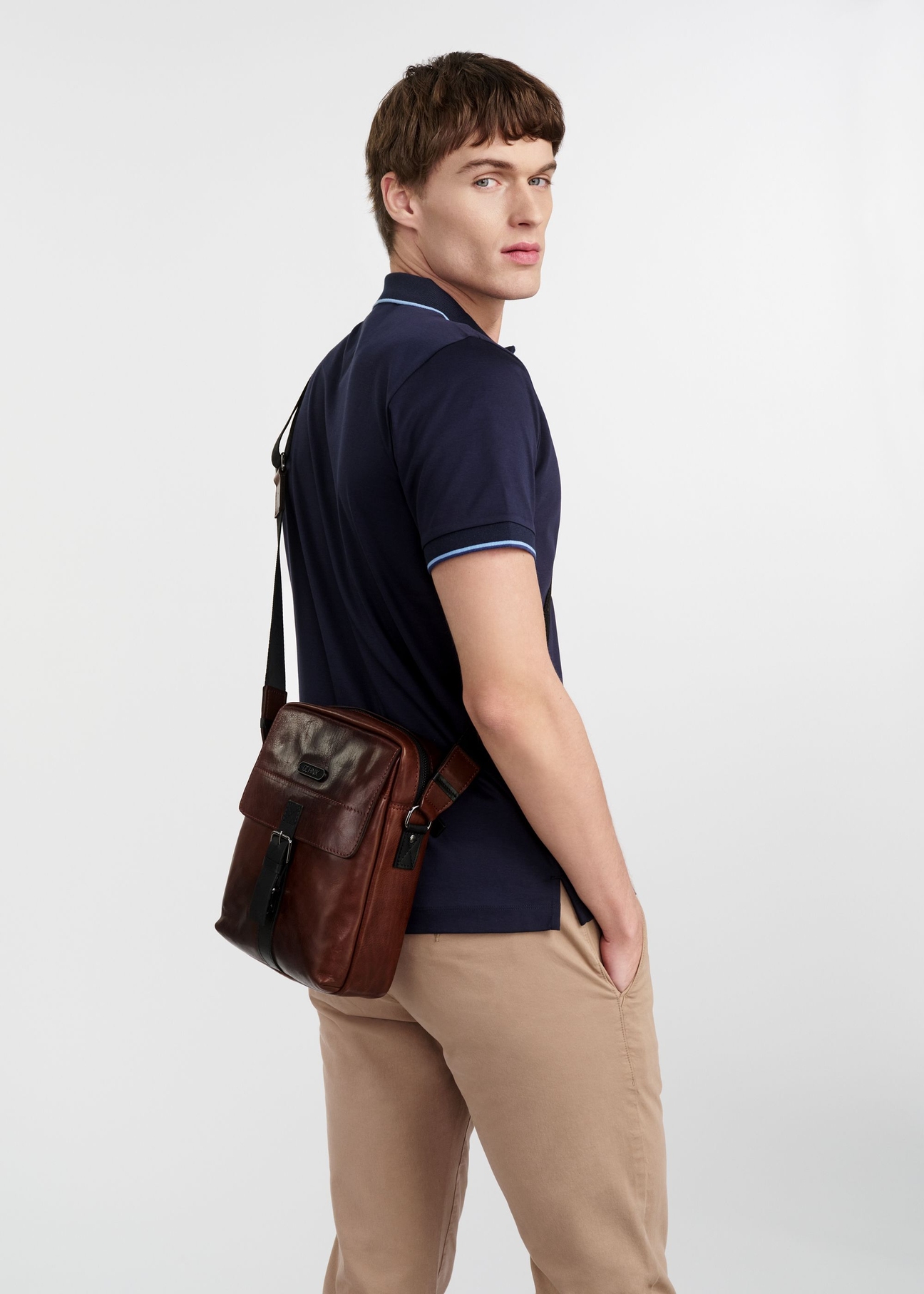 Коричнева шкіряна чоловіча сумка TORMS-0104-1H(W26), вигляд виробу збоку на силуеті моделі, на світлому фоні.
