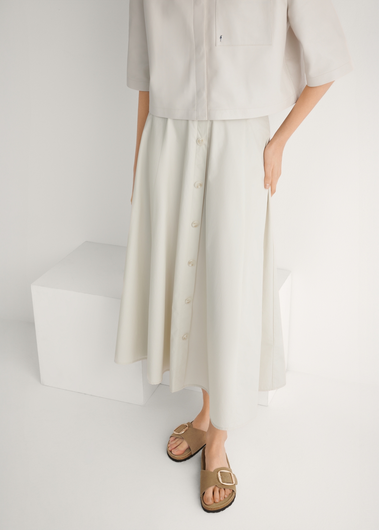 Жіночі шкіряні шльопанці холодного бежевого кольору BUTYD-1157-1K(W26), вигляд виробу спереду на ногах моделі.