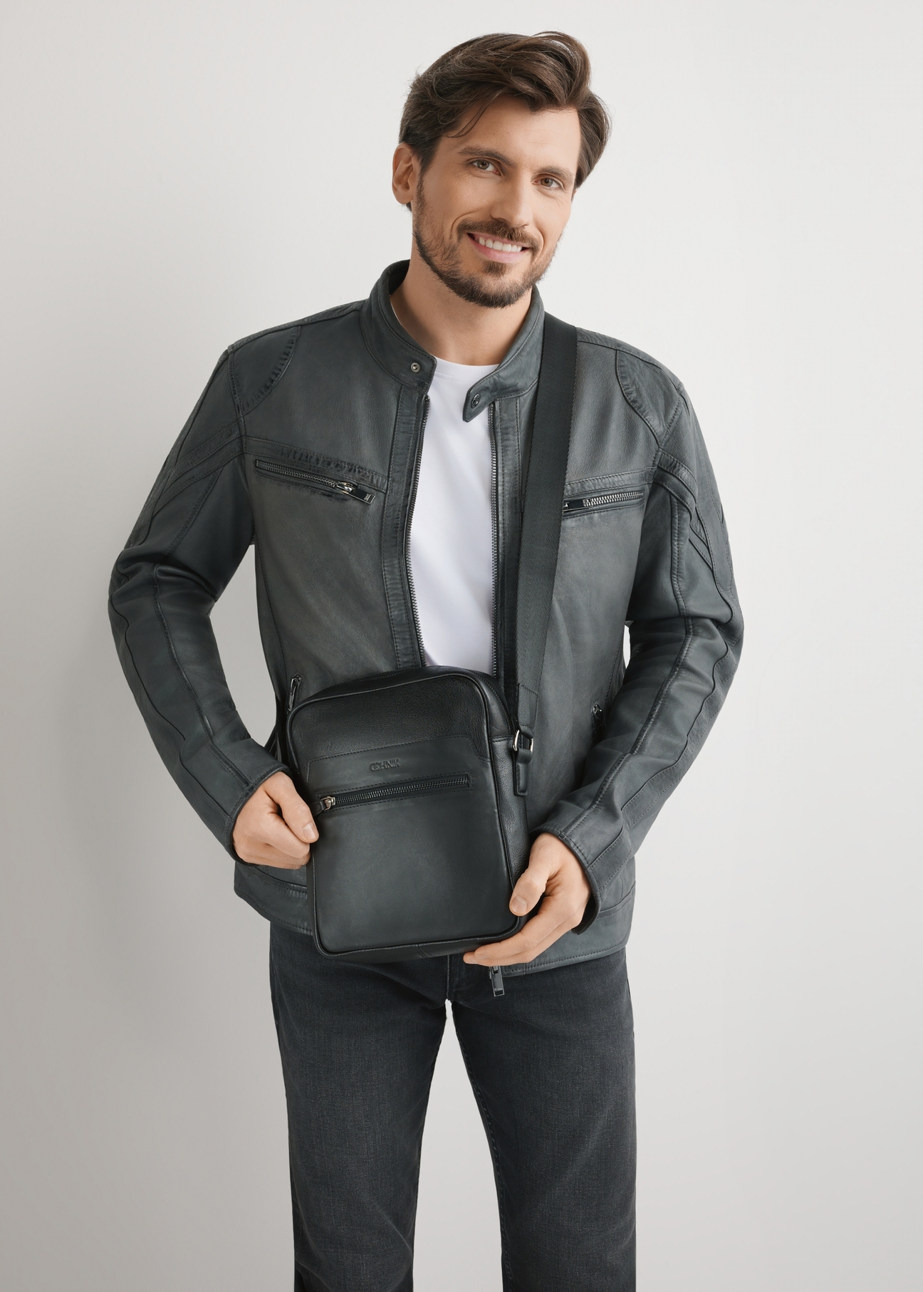 Чоловіча чорна шкіряна сумка-месенджер TORMS-0499-99(W26), вигляд виробу на плечі моделі. Видно половину силуету.