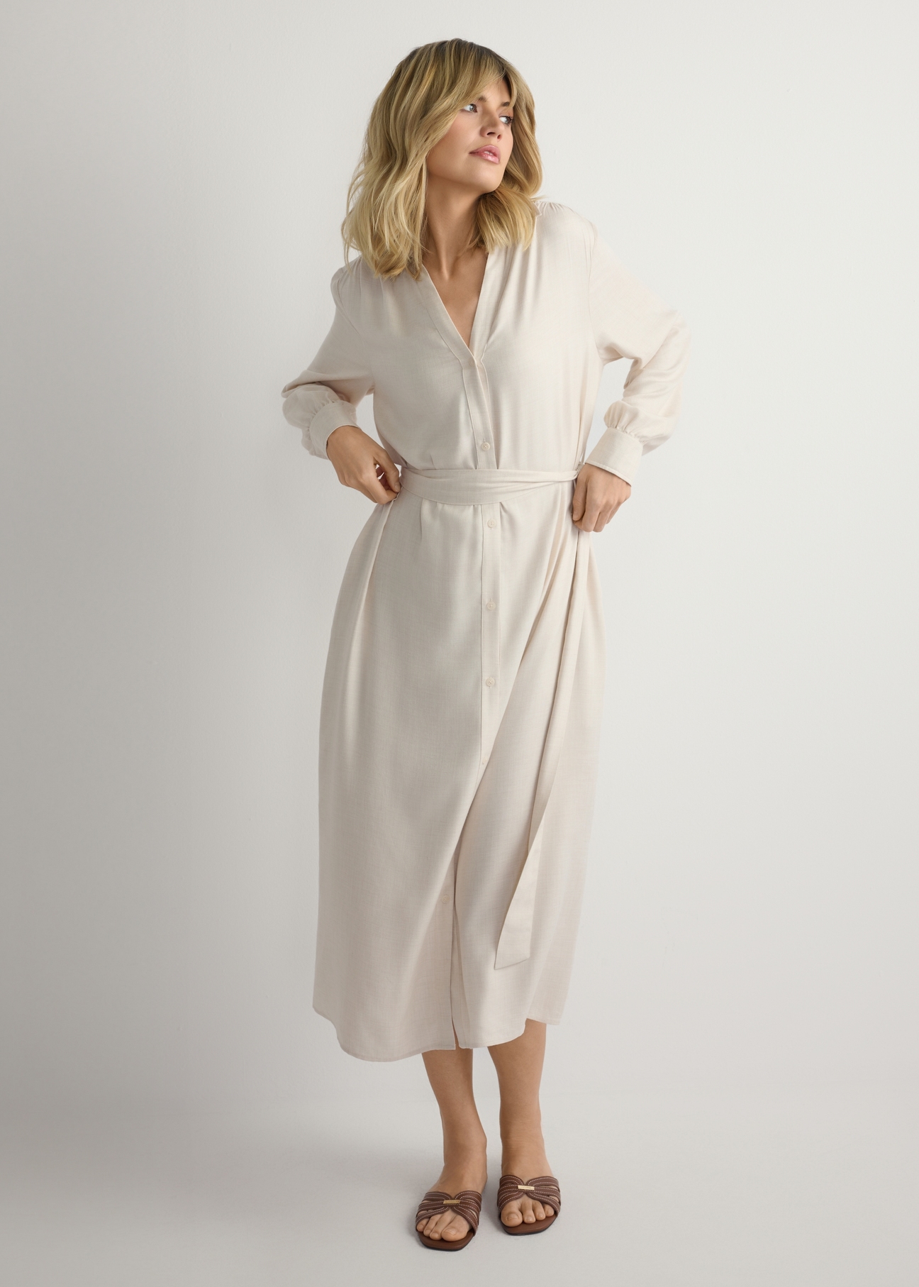 Світло-бежева жіноча сукня міді SUKDT-0269-1A(W26), вигляд виробу спереду на моделі. Видно половину силуету.