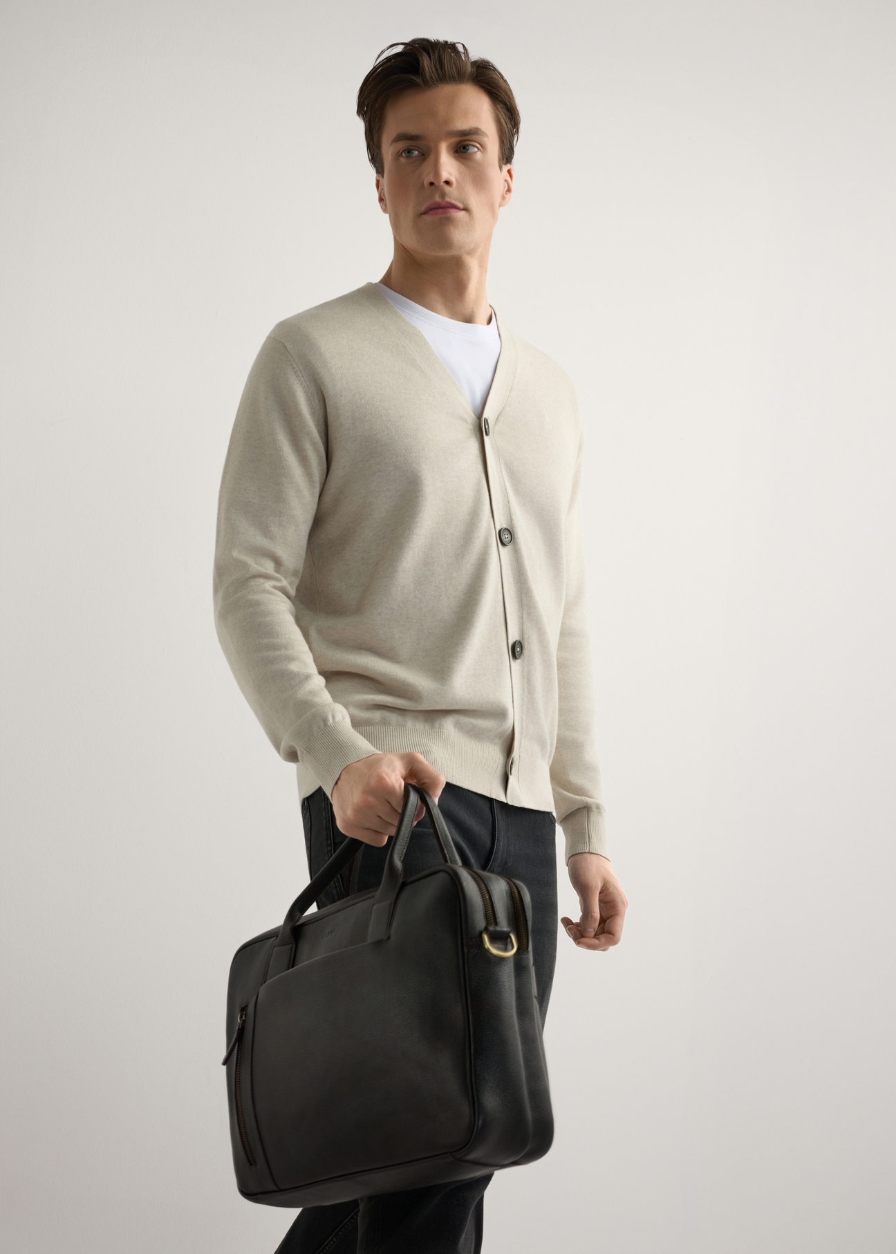 Коричнева чоловіча шкіряна сумка TORMS-0504-1I(W26), діагональний вигляд виробу в руці моделі. Видно половину силуету.