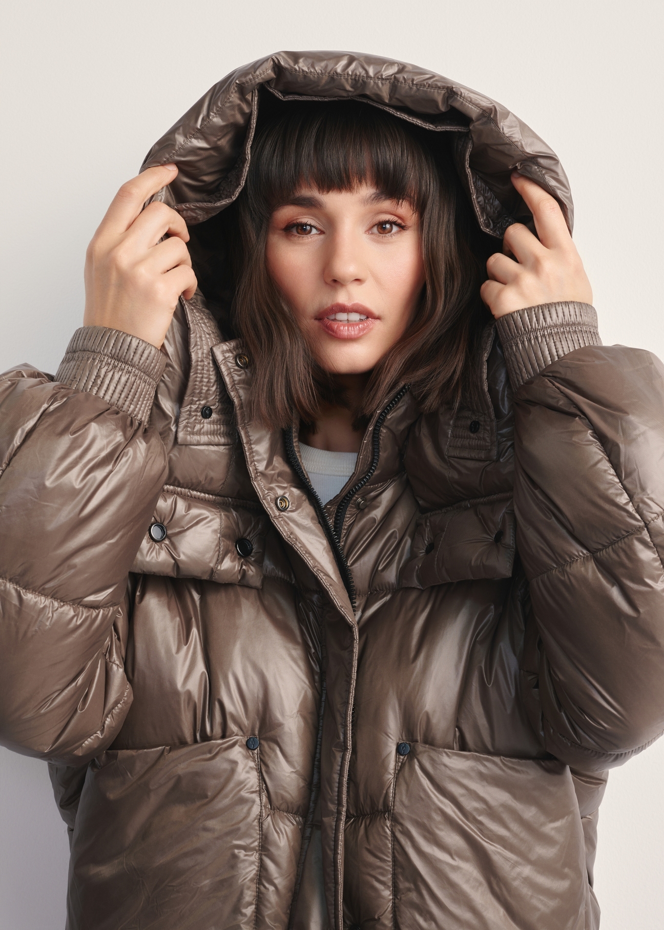 Жіноча коротка коричнева куртка KURDT-0608-82(Z25), вигляд виробу з капюшоном на моделі на світлому фоні.