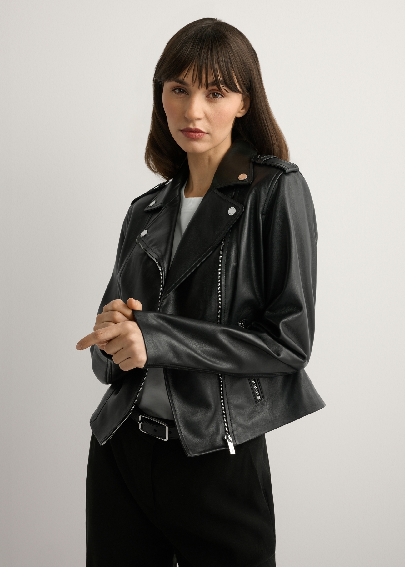 Жіноча чорна шкіряна куртка KURDS-0601-99(W26), вигляд виробу спереду на моделі. Видно половину силуету.