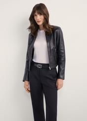 Жіноча чорна коротка шкіряна куртка KURDS-0294-99(KS), вигляд виробу спереду на моделі. Видно половину силуету.