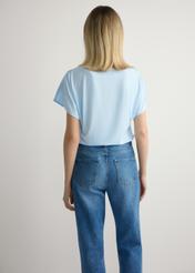 Світло-блакитна жіноча блузка BLUDT-0206-7A(W26), вигляд виробу ззаду на моделі. Видно половину силуету.