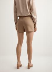 Жіночі елегантні шорти верблюжого кольору SZODT-0018-1D(W26), вигляд виробу ззаду на моделі. Видно половину силуету.