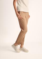 Жіноче спортивне взуття кремового кольору з шкіри BUTYD-1099-11(Z25), вигляд виробу на ногах моделі на світлому фоні.