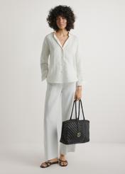 Темно-коричнева плетена жіноча сумка TORES-1301-1I(W26), вигляд виробу в руці моделі. Видно повністю.