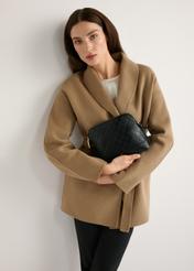 Чорна жіноча сумка з монограмою TOREC-1180-9P(W26), вигляд виробу в руках моделі. Видно половину силуету.