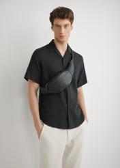 Чоловіча чорна шкіряна поясна сумка TORMS-0497-99(W26), вигляд виробу спереду на силуеті моделі.