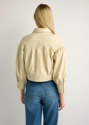 Світло-жовта жіноча шкіряна куртка KURDS-0574-2A(W26), вигляд виробу ззаду на моделі. Видно половину силуету.