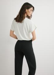 Кремова жіноча блузка BLUDT-0206-0B(W26), вигляд виробу ззаду на моделі. Видно половину силуету.