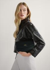 Чорна жіноча сумка зі штучної шкіри TOREC-1081-99(W26), вигляд виробу в руках моделі. Видно половину силуету.