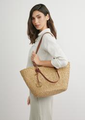 Велика жіноча солом'яна сумка-шопер TOREC-1217-1E(W26), вигляд виробу в руках моделі. Видно половину силуету.