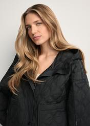 Čierna krátka prešívaná bunda oversize KURDT-0660-99(W26) - pohľad spredu na produkt, na modelke, na svetlom pozadí. Detail.