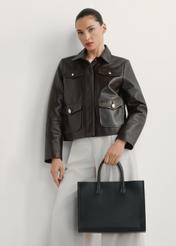 Жіноча чорна шкіряна сумка TORES-1206-9I(W26), вигляд виробу в руці моделі. Видно половину силуету.