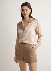 Жіночі елегантні шорти верблюжого кольору SZODT-0018-1D(W26), вигляд виробу спереду на моделі. Видно половину силуету.