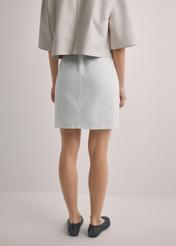 Кремова джинсова міні-спідниця SPCDT-0126-0B(W26), вигляд виробу ззаду на моделі. Видно половину силуету.