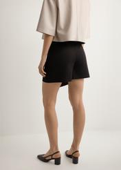 Жіночі чорні кюлоти SZODT-0008-99(W26), вигляд виробу ззаду на моделі. Видно половину силуету.