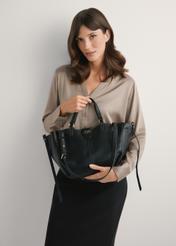 Чорна жіноча сумка через плече TOREC-1231-99(W26), вигляд виробу в руках моделі. Видно половину силуету.