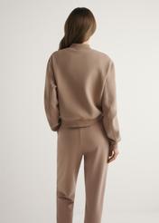 Жіноча толстовка верблюжого кольору BLZDT-0121-1D(W26), вигляд виробу ззаду на моделі. Видно половину силуету.