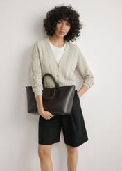 Коричнева жіноча сумка-шопер TOREC-1240-1H(W26), вигляд виробу в руках моделі. Видно половину силуету.