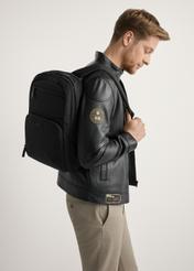 Великий чорний чоловічий рюкзак TORMN-0389-99(W26), вигляд товару на спині моделі, на світлому фоні.