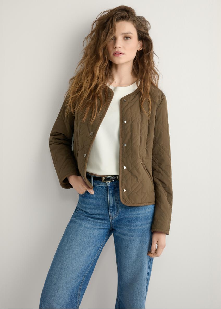 Жіноча стьобана куртка коричневого кольору KURDT-0620-1H(W26), вигляд виробу спереду на моделі. Видно половину силуету.